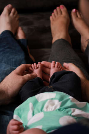An overhead vertical shot of the father and the mother holding their babyの写真素材