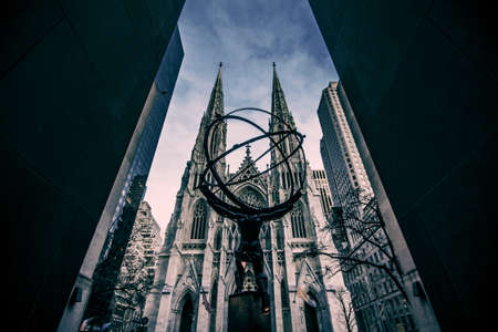 A vertical low angle shot of the St. Patrick's Cathedral, with Atlas statue of the Rockefeller...
