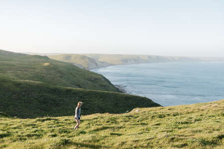 A high angle shot of hills covered in the greenery surrounding the ocean