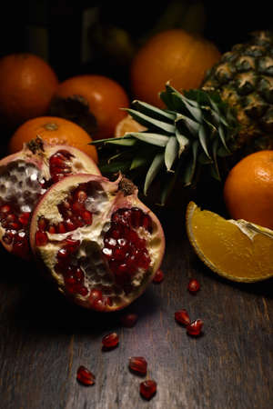A vertical shot of different tropical fruits on a wooden surfaceの写真素材