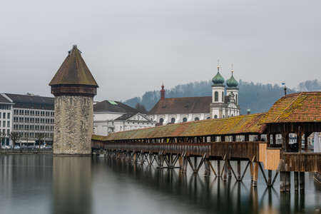 The Lucerne Jesuit Church surrounded by water under a cloudy sky in Lucerne in Switzerlandの写真素材