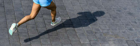 An athletic female with shorts doing a morning run - healthy lifestyle conceptの写真素材