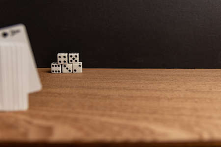 A selective focus shot of dices in the distance on a wooden surfaceの写真素材