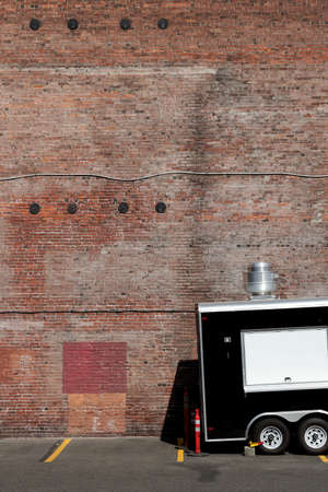 PORTLAND, UNITED STATES - Jul 26, 2019: A vertical shot of a truck parked in front of a brick wall...