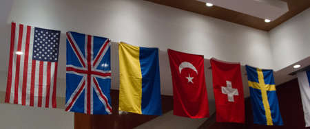 A wide shot of different country flags hanging from the ceiling