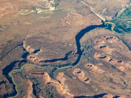 Aerial view of the colorado river snaking across the desert with gorges and cliffsの写真素材