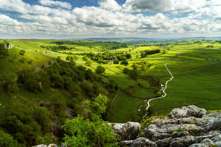 A high angle shot of a beautiful green valley under the cloudy sky