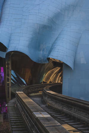 A colorful abstract architecture with a sky-rail passing through it under sunlight