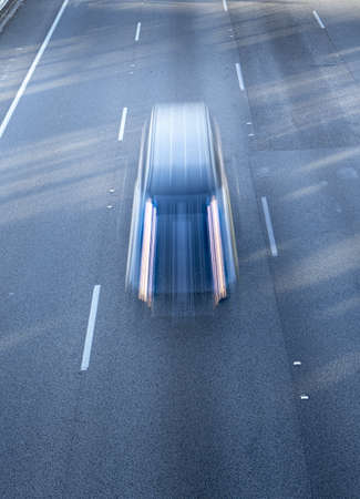 A vertical high angle shot of a car going very fast on the highwayの写真素材