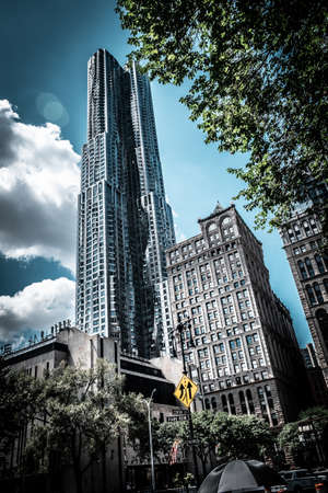 A vertical low angle shot of a commercial building touching the skyの写真素材