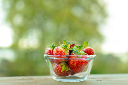A bowl of fresh strawberries on a blurred backgroundの写真素材