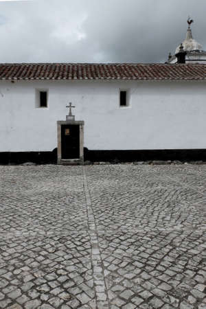 A vertical shot of a beautiful white building on a paved street under the cloudy skyの写真素材
