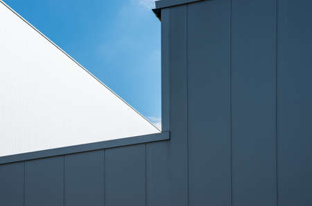 A low angle shot of a white building with the clear blue sky in the background