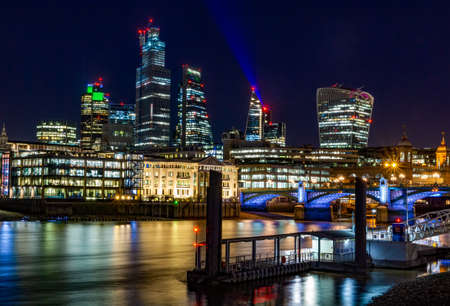 A picture of London with modern buildings and a bridge during the night with the city lightsの写真素材