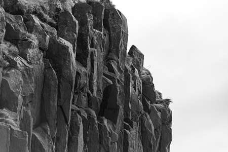 A black and white closeup shot of the big rock formations on the beachの写真素材