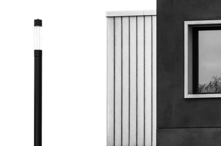 A low angle shot of the black and white facade of a building with the bright sky in the background
