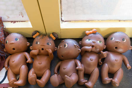 A high angle view of dolls without clothes near a yellow window under sunlightの写真素材
