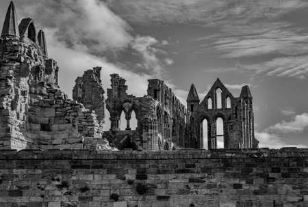 A greyscale of the ruins of Whitby Abbey in England under a cloudy skyの写真素材