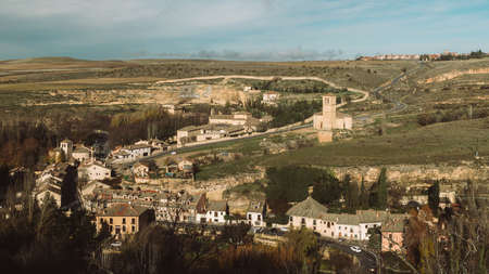 A high angle shot of the beautiful old buildings among the trees captured in Segovia, Spain