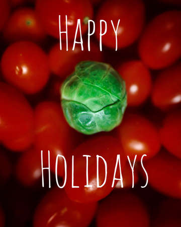 A vertical shot of a cabbage on a pile of tomatoes with a Happy Holiday text