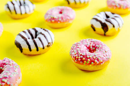A closeup shot of delicious donuts on a yellow surface - perfect for a cool wallpaperの写真素材