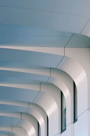 A vertical shot of the white facade of a modern building