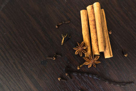 A high angle closeup shot of cinnamon sticks on a wooden surface