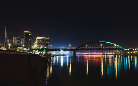 BELGRADE, SERBIA - Dec 17, 2019: Belgrade Waterfront and old railway bridge and Gazelle bridge over the Sava river at nightの写真素材