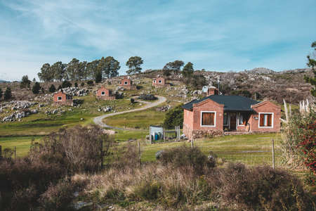 A scenery of houses built in the middle of a green mountainous scenery
