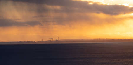 A golden sunset covered with the clouds during the evening - a cool picture for backgroundsの写真素材