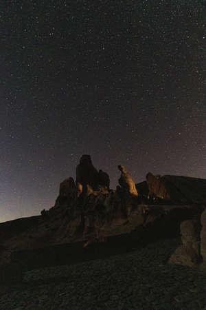 A vertical shot of a rocky scenery under the magical night skyの写真素材