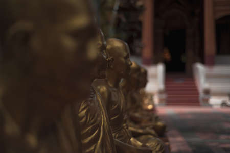 A selective focus shot of golden statues in front of a temple
