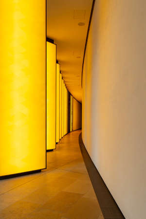 A vertical shot of the illuminated narrow hallway in a modern buildingの写真素材