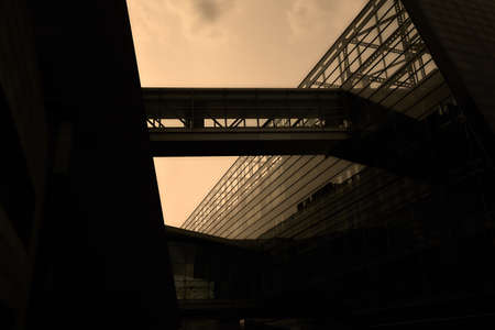 A low angle view of a modern building with glass walls under a cloudy sky during sunset