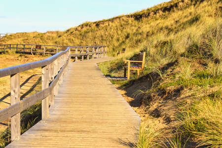 A wooden path in the hills of the Red Cliff, Sylt, Germany on a sunny dayの写真素材