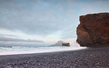 A huge rock formation on a rocky beach in North Iceland