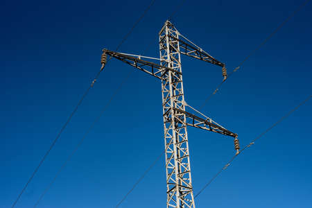A low angle shot of a transmission tower under the clear blue skyの写真素材