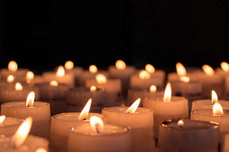 A closeup shot of lighted candles for a religious ceremony in a dark area