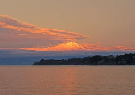 A sunset over the mountain at the ocean shoreの写真素材
