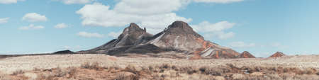 A panoramic shot of mountains touching the white fluffy cloudsの写真素材