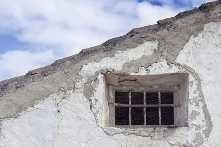 A closeup shot of an abandoned old building touching the cloudy skyの写真素材