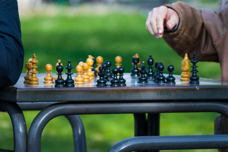 A person getting ready to take a step in a chess game with a blurred backgroundの写真素材