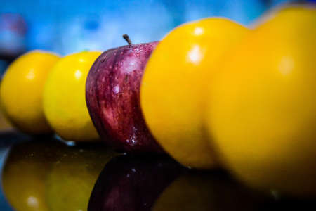 A red apple among yellow apples with a blurred backgroundの写真素材