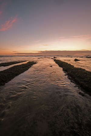 A beautiful scenery of the sunset reflecting in the ocean with its warm colors