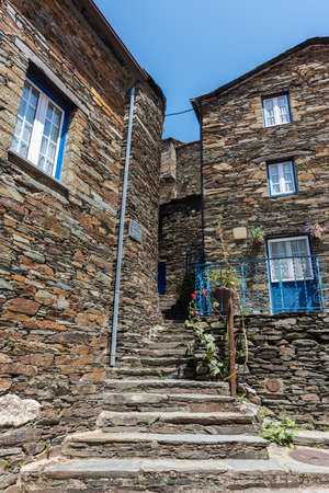 A staircase surrounded by stone buildings under sunlight in Piodao village in Portugalの写真素材
