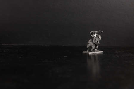 A grayscale selective focus shot of mythical creature riding a boar figurineの写真素材