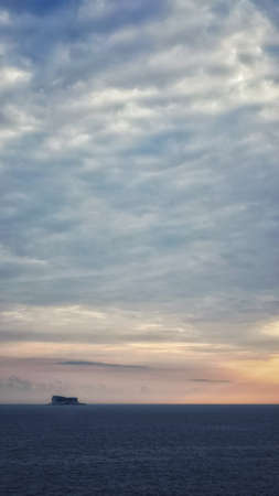 A vertical shot of a breathtaking sunset over the oceanの写真素材