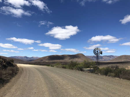 A beautiful view of a road with mountains in the distance under a blue skyの写真素材