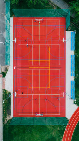 A vertical high angle shot of a basketball field with a red floor in an outdoor parkのeditorial素材