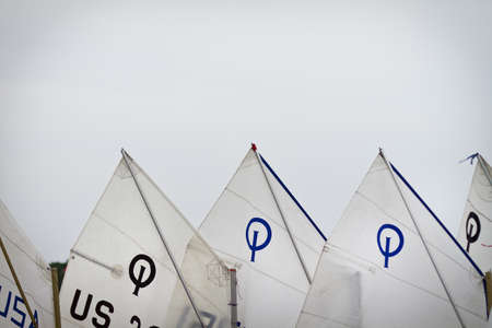 WAYZATA, UNITED STATES - Jun 24, 2011: Opti Sailboat sails against an even cloudy sky.